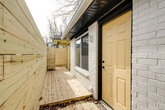a view of a balcony with wooden floor and a glass door