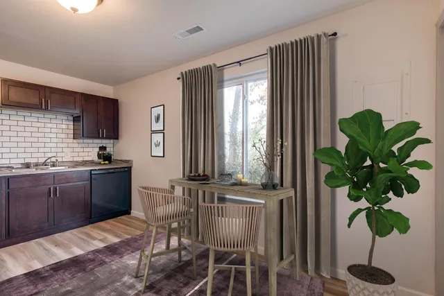 a kitchen with stainless steel appliances granite countertop a potted plant and a wooden floors