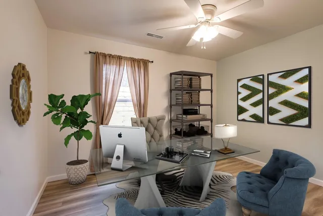 a living room with furniture flowers and a window