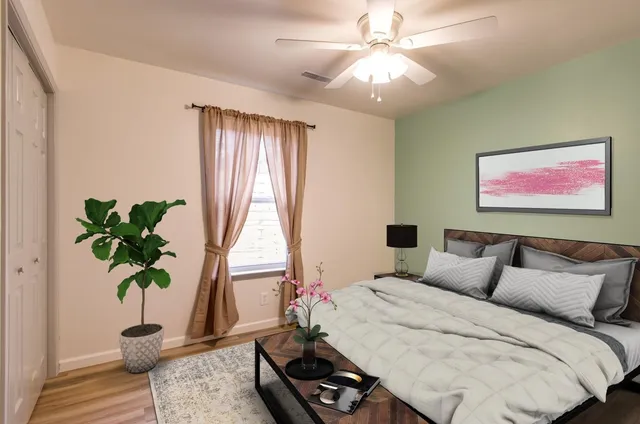 a bedroom with a bed and a potted plant