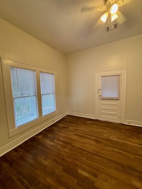 210 East Phillips Street Conroe, TX 77301 - Photo 21 of 27 a view of an empty room with wooden floor and a window