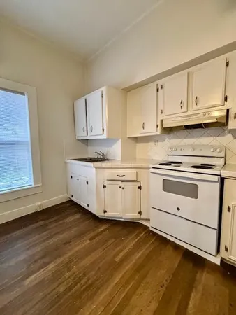 a kitchen with granite countertop white cabinets and white appliances