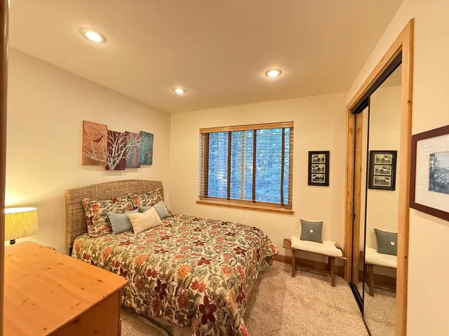 a bathroom with a granite countertop sink a toilet a mirror and bathtub