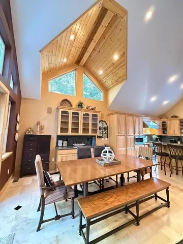 a dining room with stainless steel appliances furniture a window and kitchen view