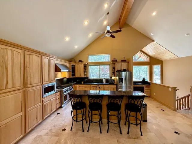 a living room with furniture fireplace and large windows