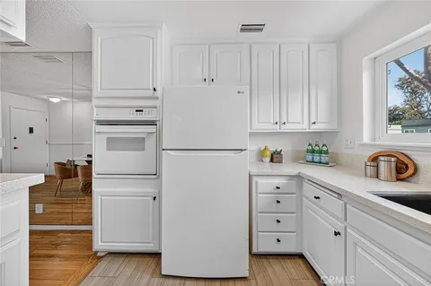 a kitchen with white cabinets and white appliances