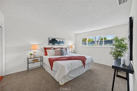 a bedroom with a bed and a potted plant