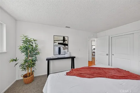 a bedroom with a bed and a potted plant