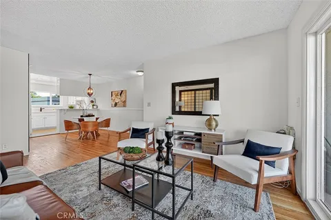 a living room with furniture a rug and a window