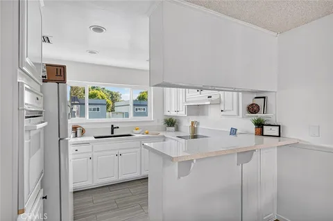a kitchen with stainless steel appliances a sink a stove and a refrigerator