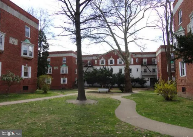 a front view of a house with garden and trees