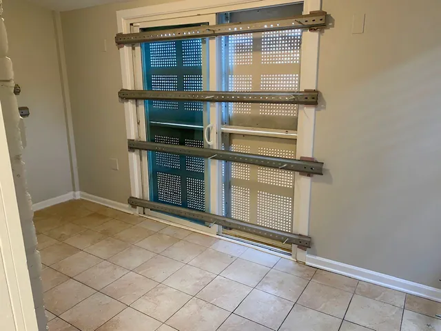 a view of an empty room with wooden floor and a cabinet