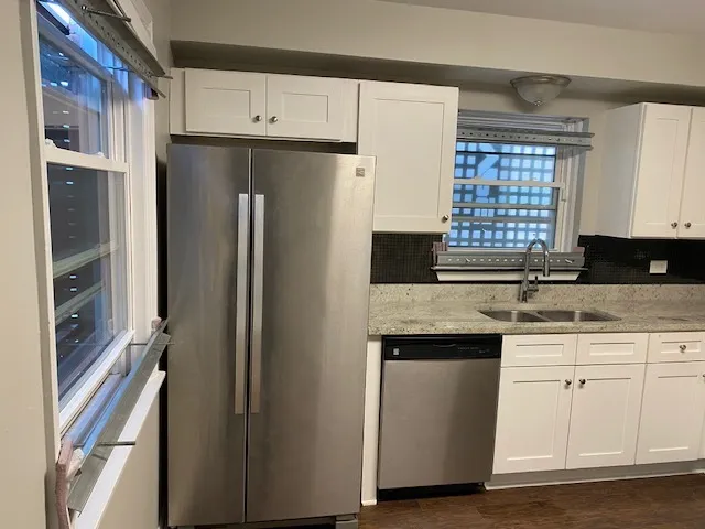 a kitchen with stainless steel appliances granite countertop a refrigerator and a sink