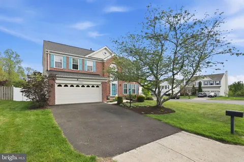 a front view of a house with a garden and trees