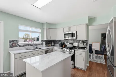 a kitchen with stainless steel appliances a sink dishwasher stove refrigerator and microwave