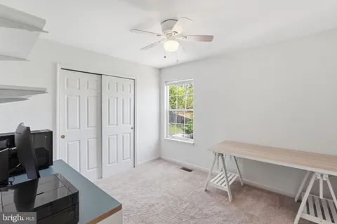 a view of a workspace with furniture and a window