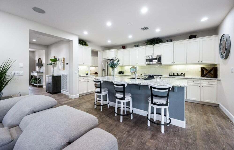 51287 Longmeadow Street Indio, CA 92201 - Photo 9 of 22 a kitchen with a dining table chairs refrigerator and cabinets