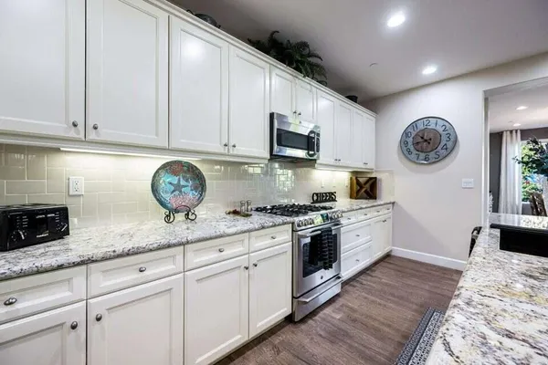 a kitchen with granite countertop a stove and cabinets