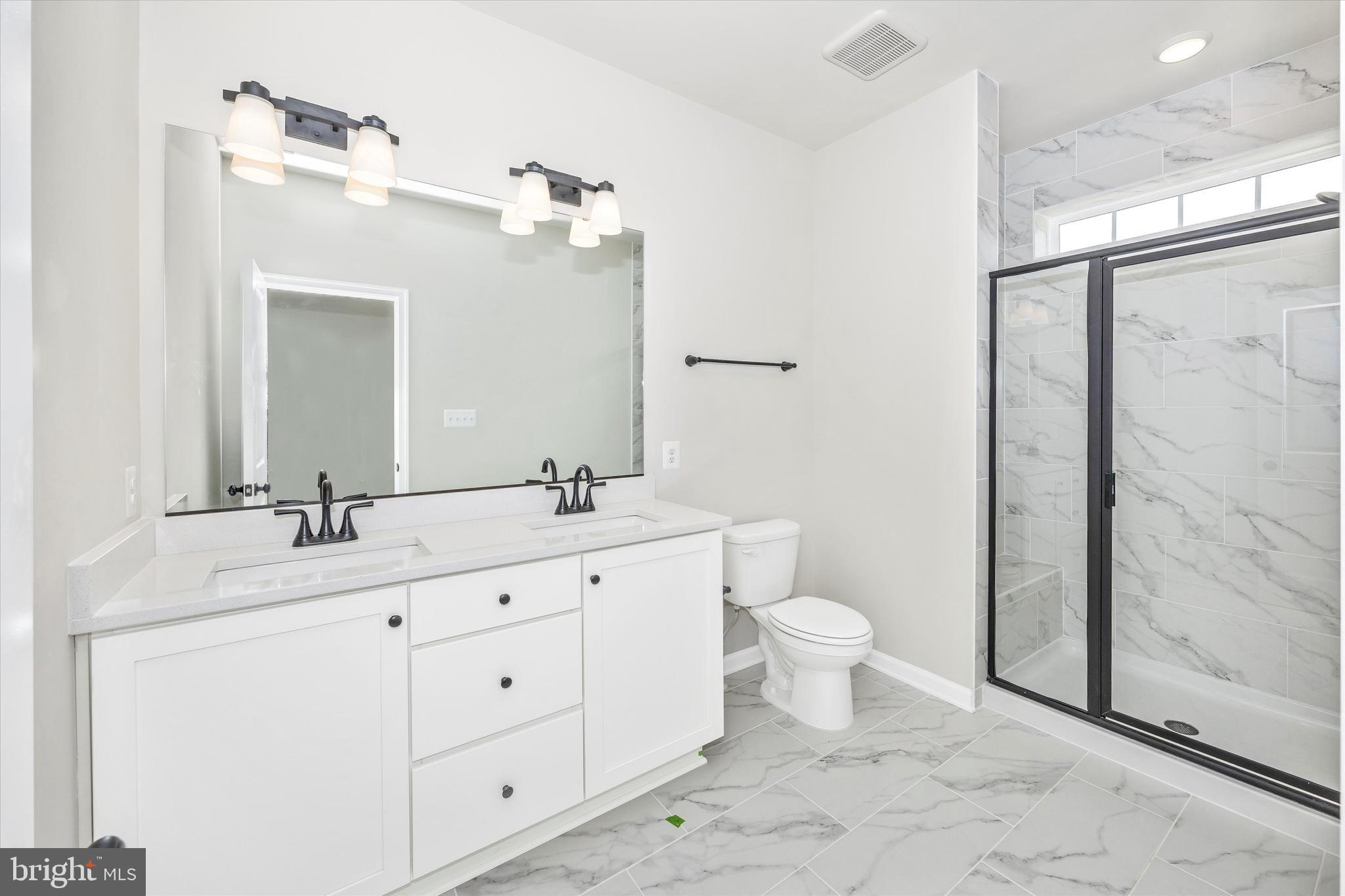 106 Spring Bank Way Frederick, MD 21701 - Photo 8 of 14 a bathroom with a double vanity sink toilet and shower