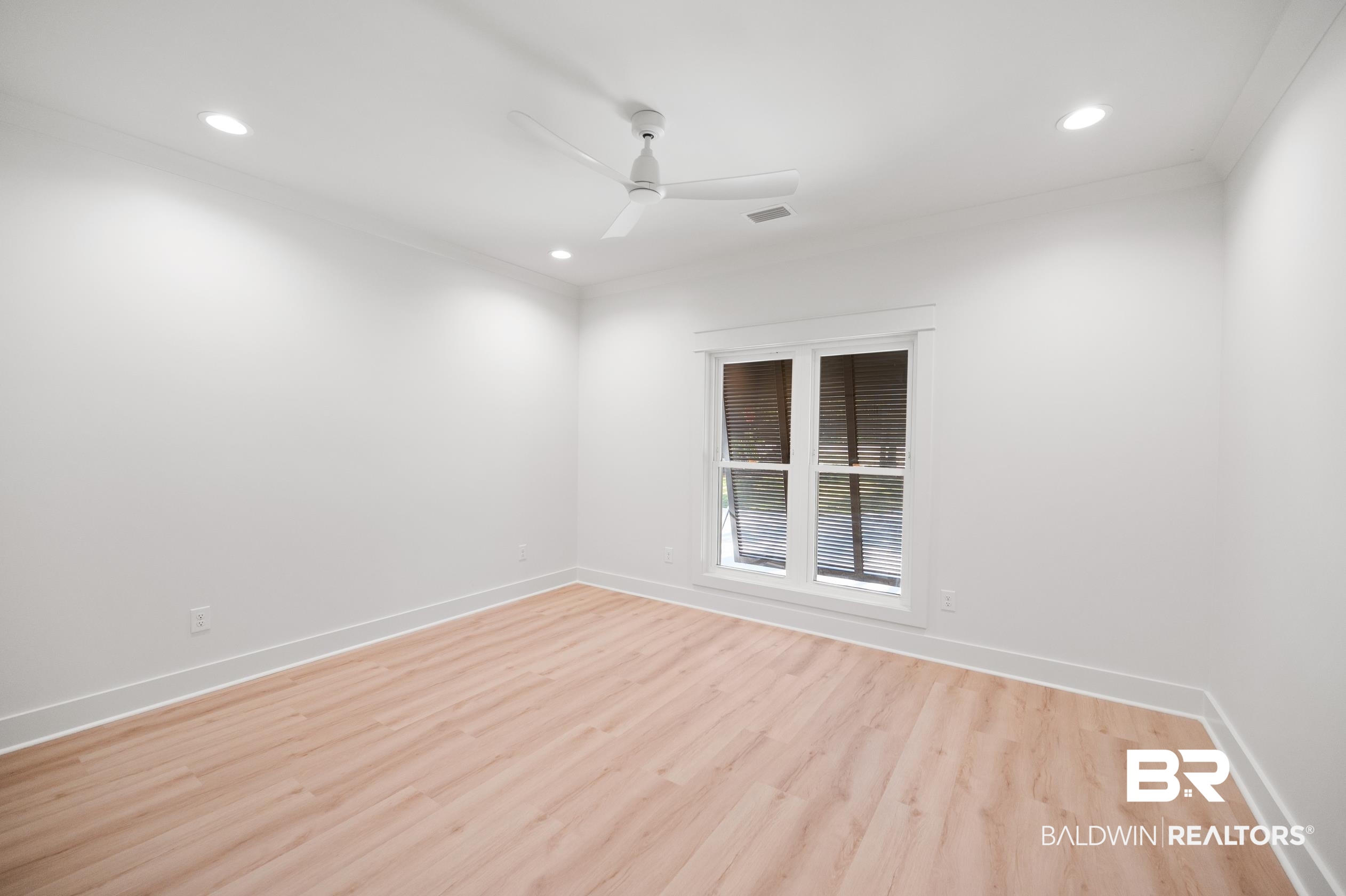 28889 Canal Road Orange Beach, AL 36561 - Photo 30 of 55 Empty room with ceiling fan, light hardwood / wood-style floors, and ornamental molding