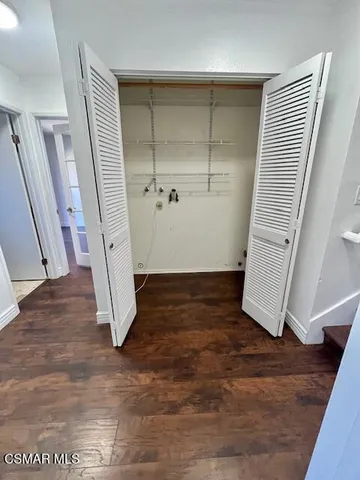 an empty room with wooden floor and staircase