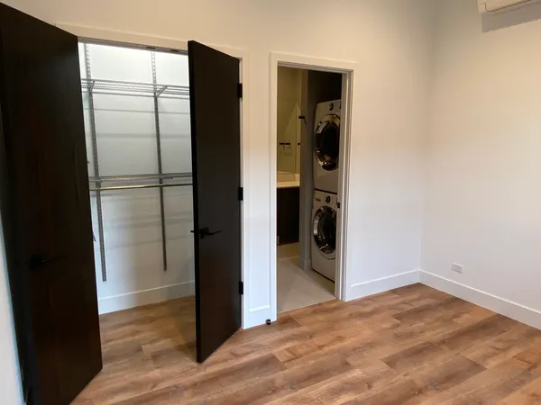 a view of empty room with wooden floor and closet