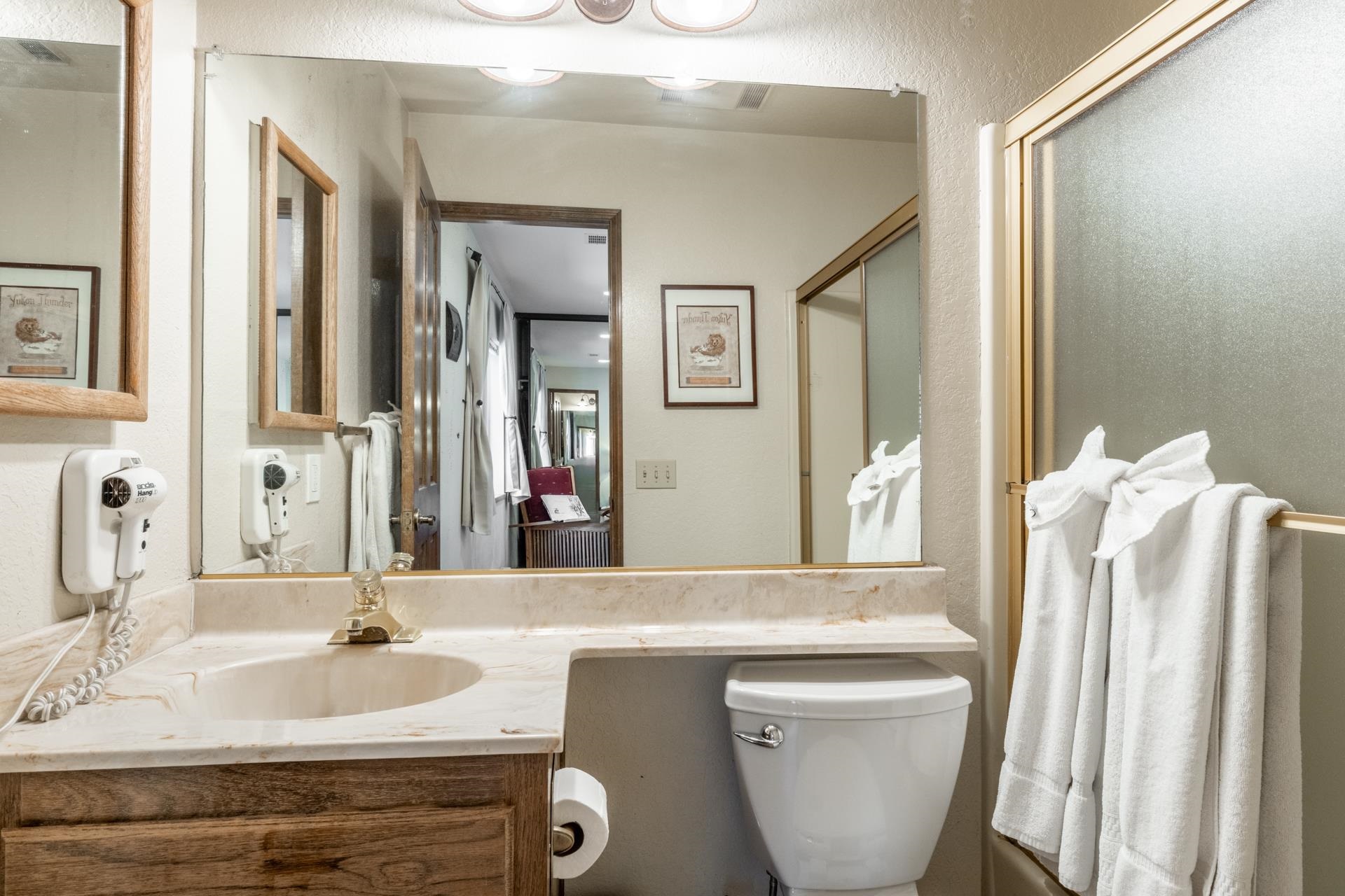 384 Joaquin Road, Unit 36 Mammoth Lakes, CA 93546 - Photo 26 of 36 Bathroom vanity with an integrated sink, a large wall-mounted mirror, and a brass-toned faucet