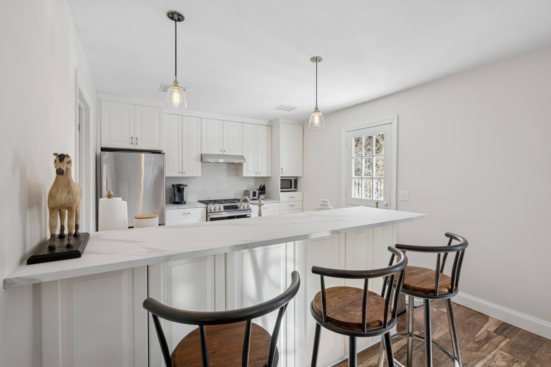 570 Hampton Road, Unit 22 Southampton, NY 11968 - Photo 11 of 26 a kitchen with stainless steel appliances granite countertop a sink a stove a refrigerator with a dining table and chairs