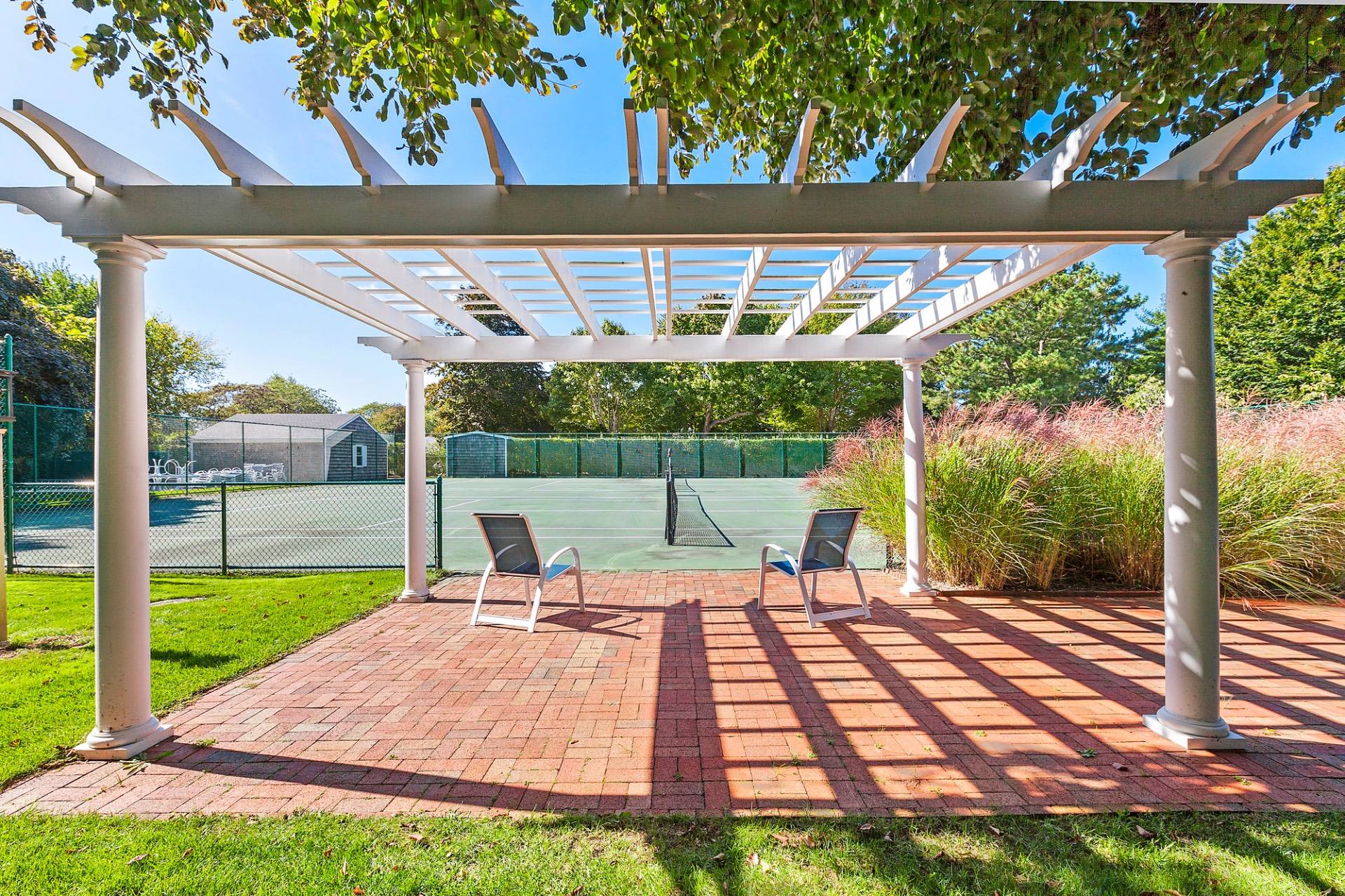 570 Hampton Road, Unit 22 Southampton, NY 11968 - Photo 24 of 26 a view of a patio with a table chairs and a backyard