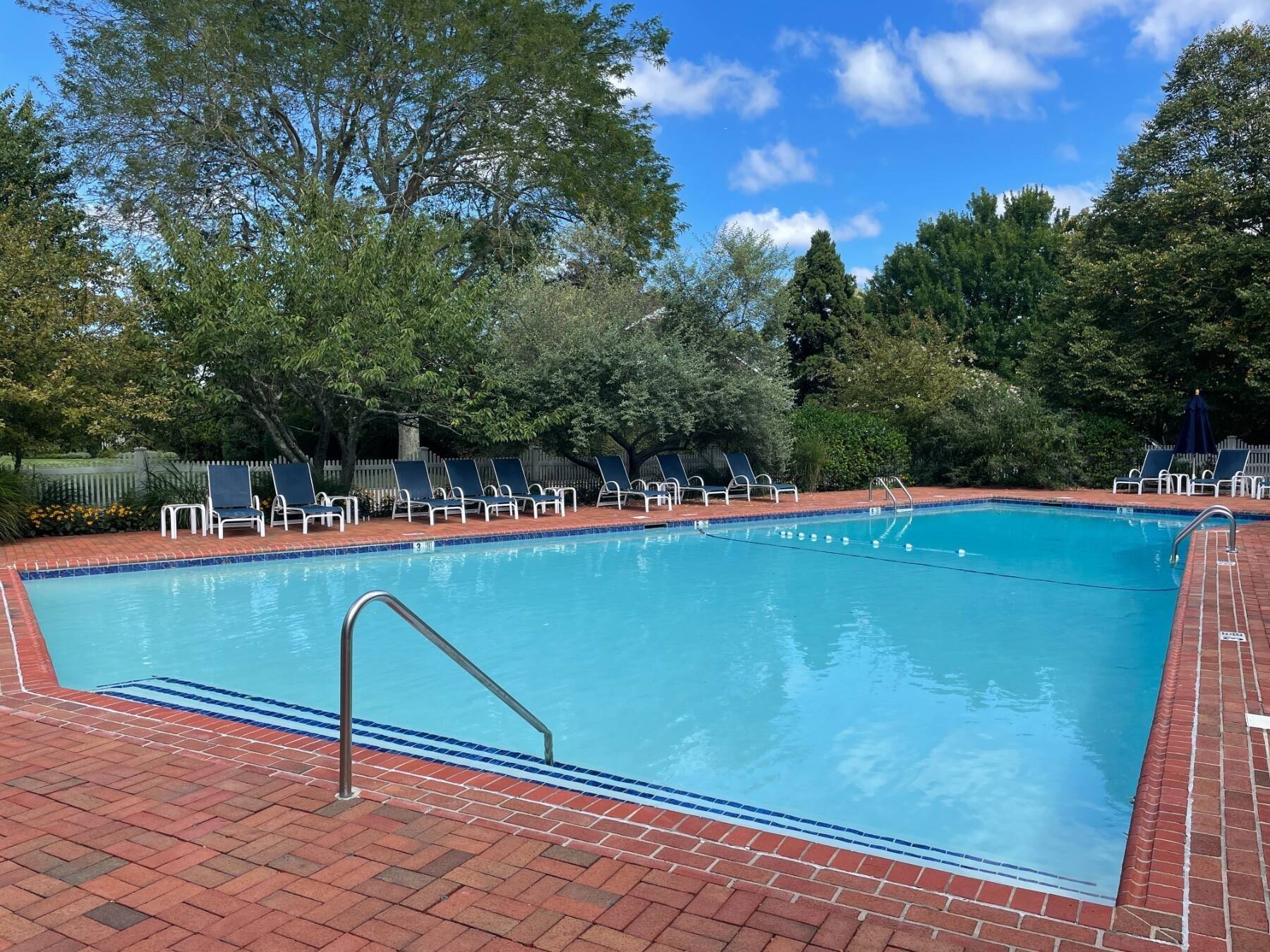 570 Hampton Road, Unit 22 Southampton, NY 11968 - Photo 26 of 26 a view of a swimming pool with a bench