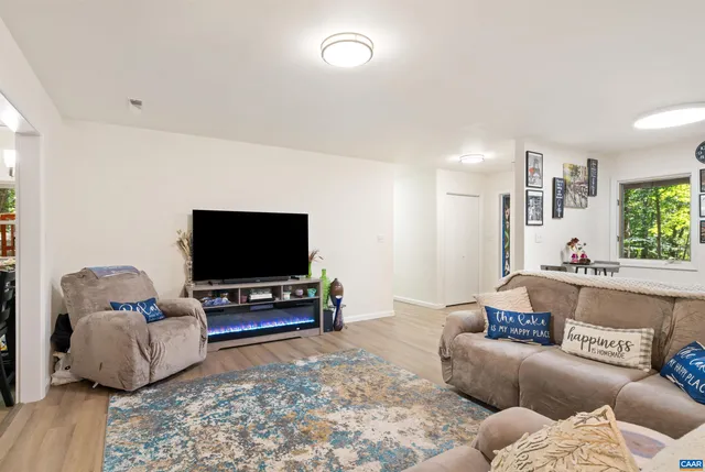 a living room with furniture and a view of kitchen