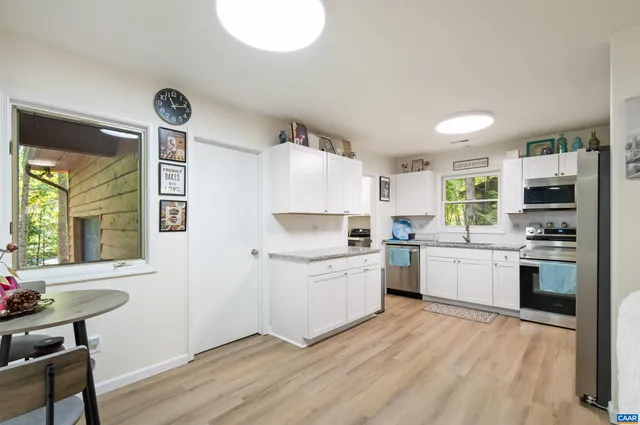 a kitchen with stainless steel appliances a refrigerator sink and microwave