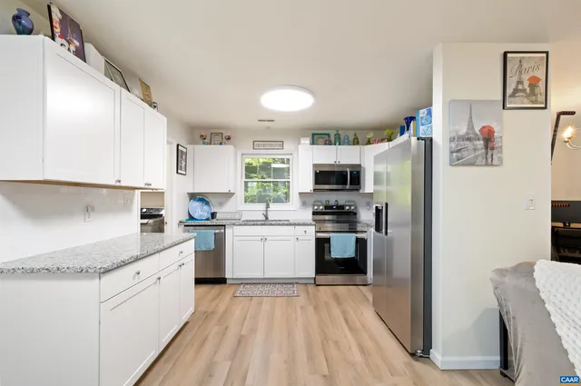 a kitchen with stainless steel appliances granite countertop a refrigerator and a stove top oven