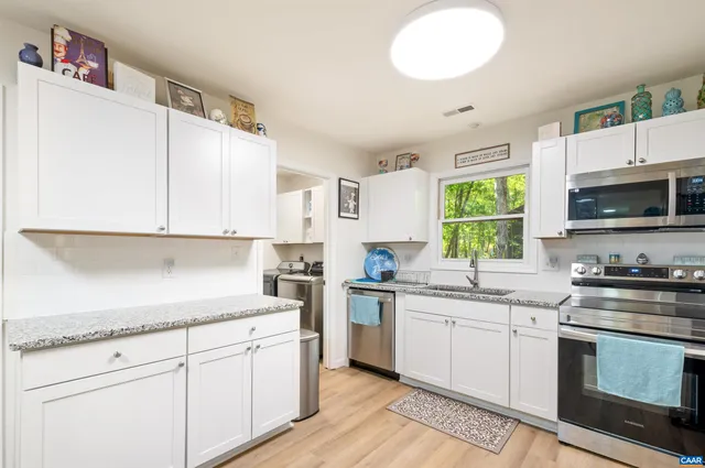 a kitchen with granite countertop stainless steel appliances a stove a sink and a microwave