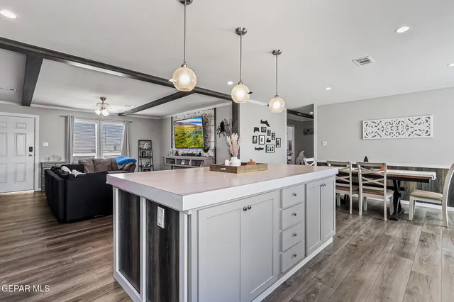 a kitchen with stainless steel appliances granite countertop a refrigerator a stove and a wooden floors