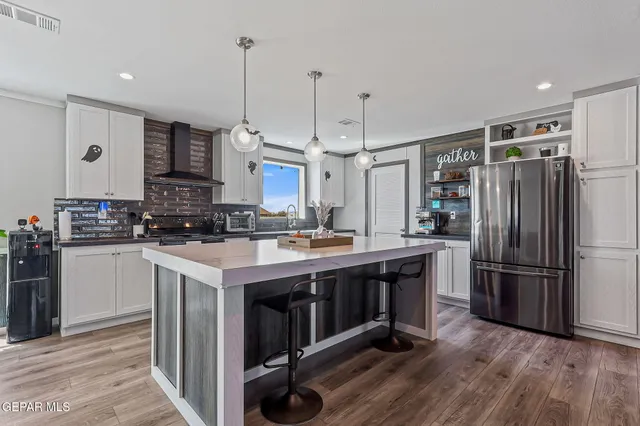 a kitchen with a table chairs refrigerator and cabinets