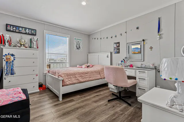 a bed room with a bed a desk and a window