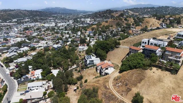an aerial view of a house with a mountain