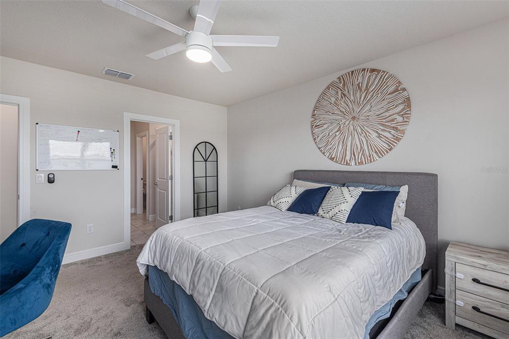 8312 Reefbay Cove Parrish, FL 34221 - Photo 16 of 36 a bedroom with a bed and a chandelier