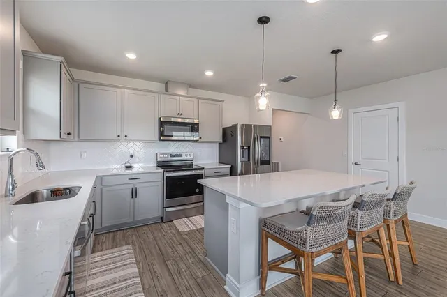 a kitchen with a dining table chairs sink and microwave