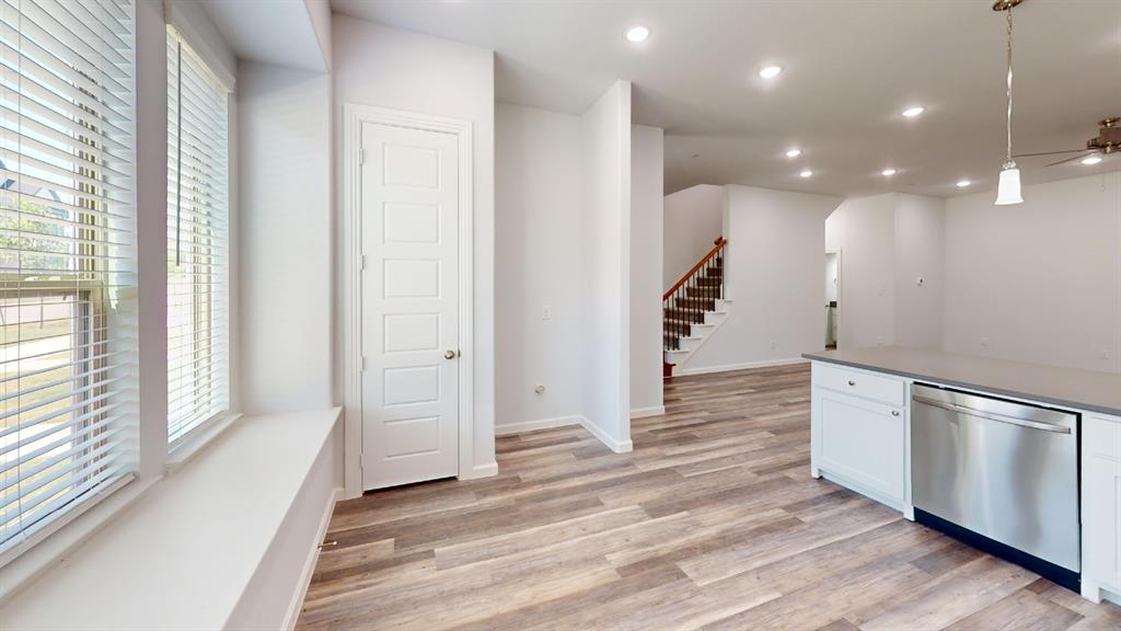 336 Buck Ridge Drive Frisco, TX 75068 - Photo 7 of 23 Open-concept living area featuring wood-finish flooring, recessed lighting, and a kitchen island with a stainless steel dishwasher