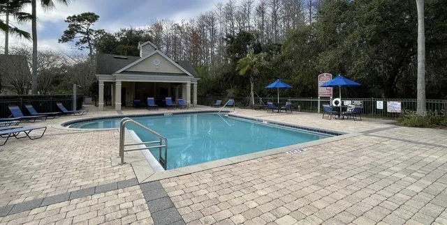 a living room with furniture potted plant and large windows