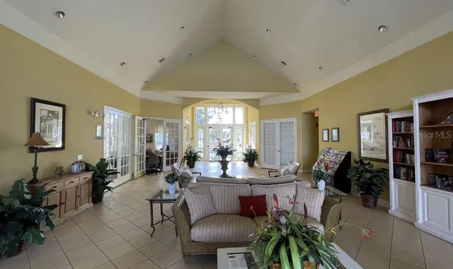 a view of swimming pool with outdoor seating and trees in the background
