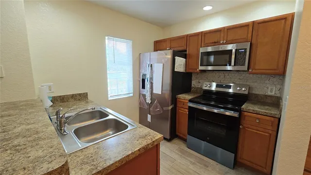 a kitchen with stainless steel appliances granite countertop a stove microwave and refrigerator