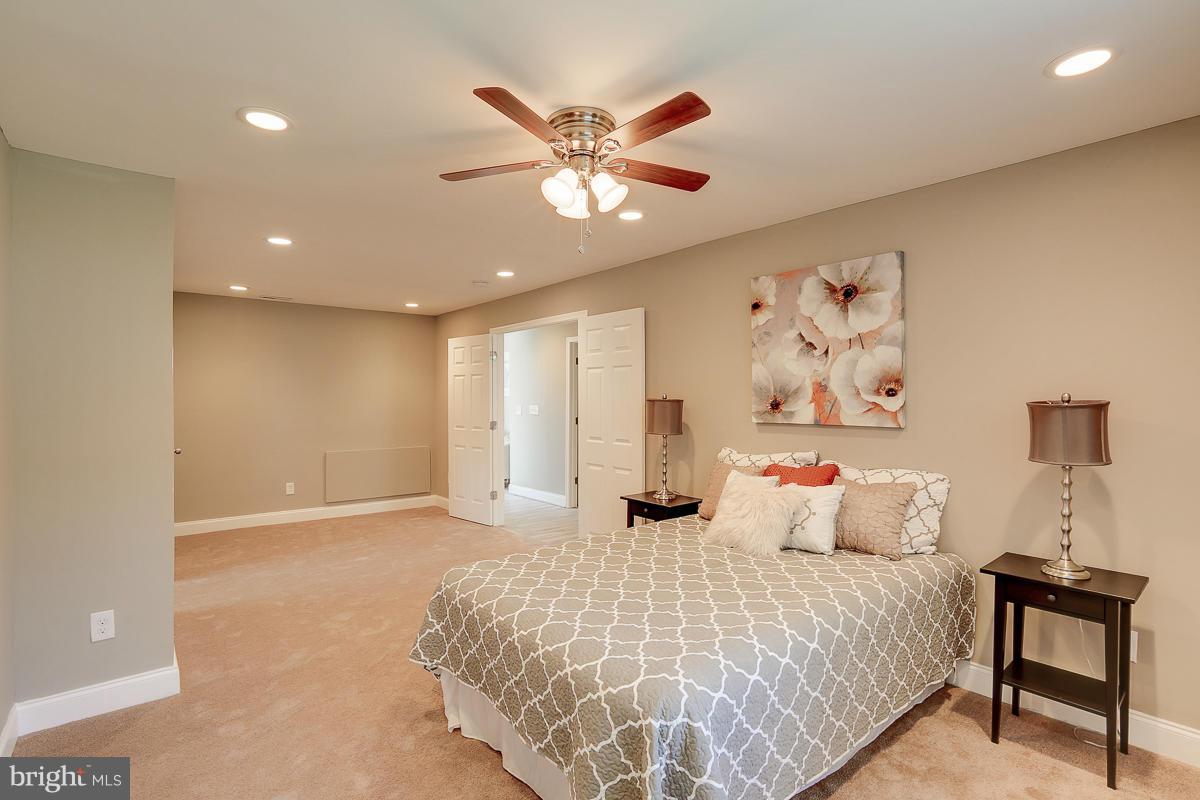 3818 Byfield Road Baltimore, MD 21207 - Photo 22 of 30 a bedroom with a large bed and a chandelier