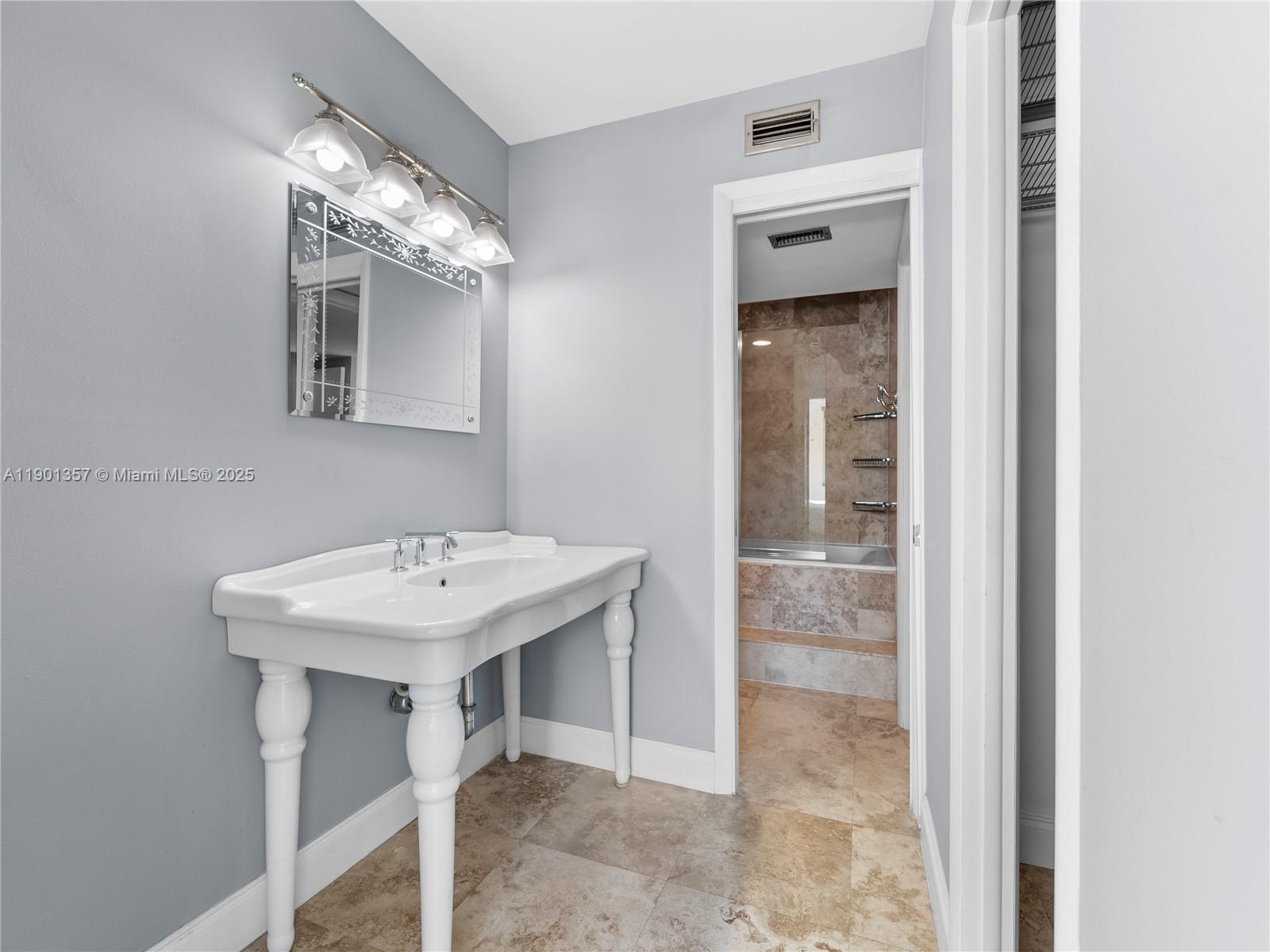 5 Island Avenue, Unit LE Miami Beach, FL 33139 - Photo 11 of 30 a bathroom with a sink a mirror and a shower