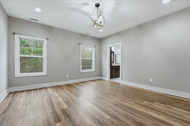 a view of empty room with wooden floor and windows