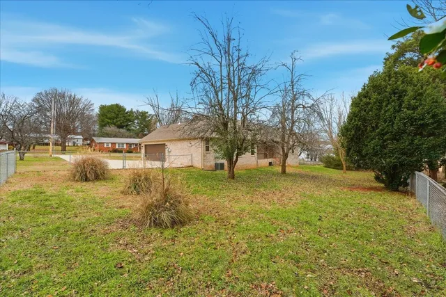 a view of a house with pool and trees in the background