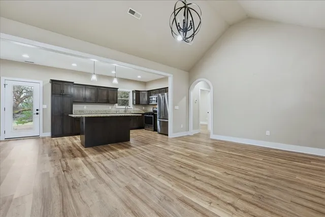a view of kitchen with granite countertop cabinets and refrigerator