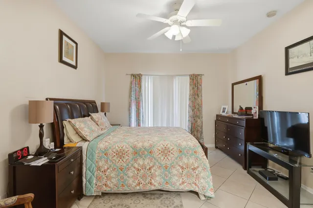 a bedroom with a bed and a flat tv screen on the dresser